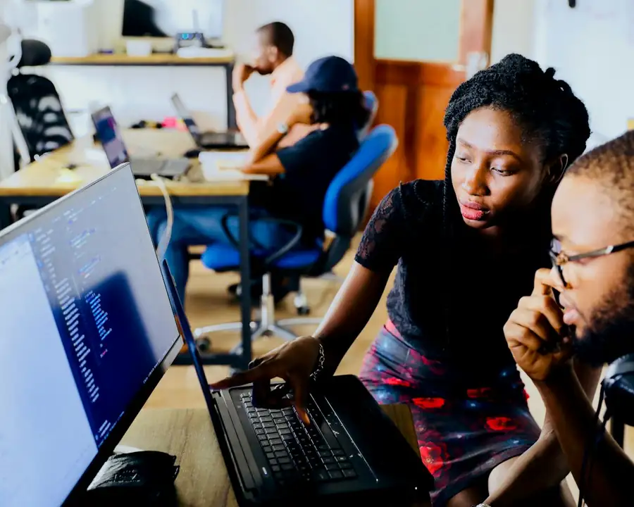 Two colleagues working together at a laptop in an office